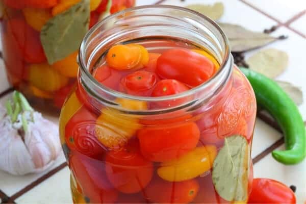 jar of orange and red cherry tomatoes in liquid