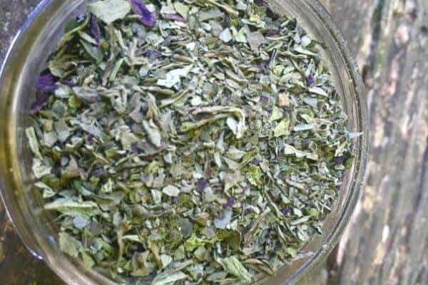 close up of fresh dried basil in a glass jar