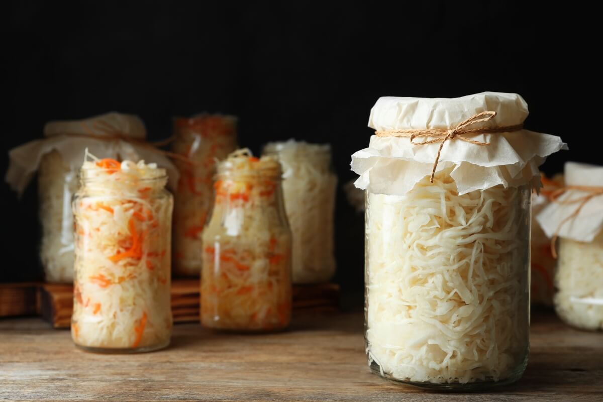 jars of fermented cabbage on wood table