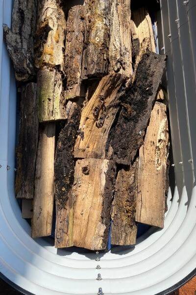 old logs filling the bottom layer of a raised bed garden 