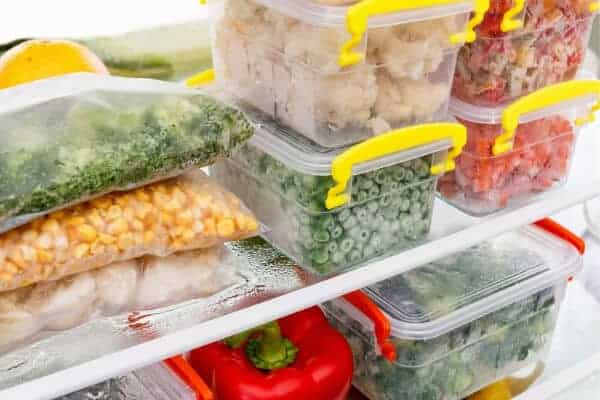 freezer full of bags of vegetables and containers of food