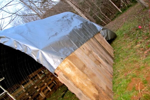 pallet shelter with tarp stretched over roof