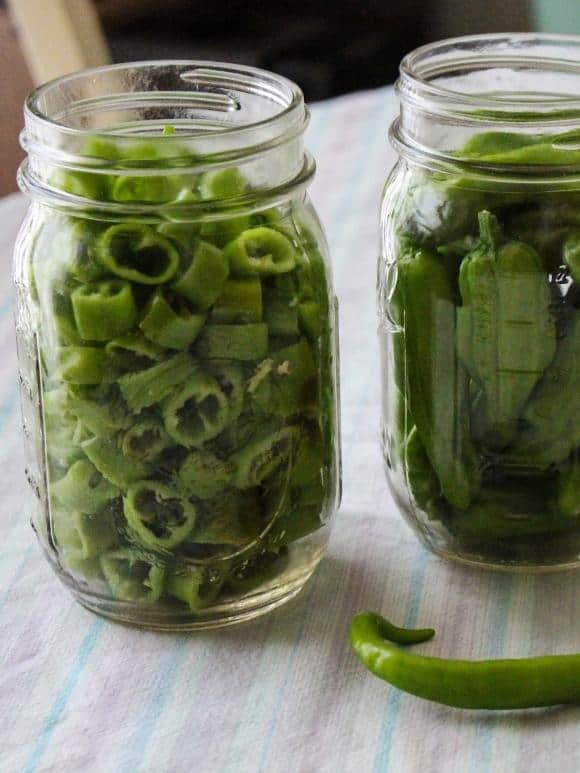 jars of green hot peppers in a jars to pickle