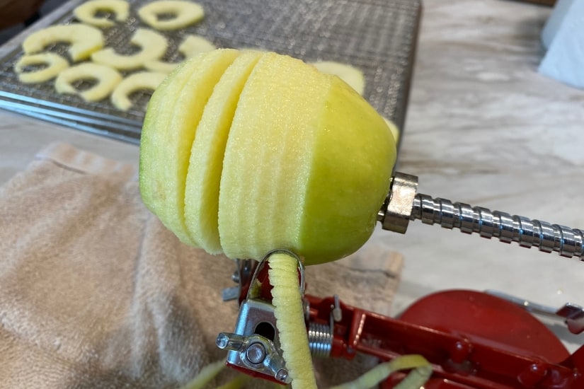 apple being cut by a coring and slicing machine